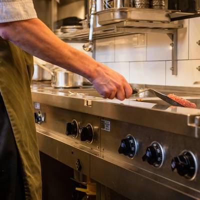 Chef reviews labeled food pans in a walk-in cooler