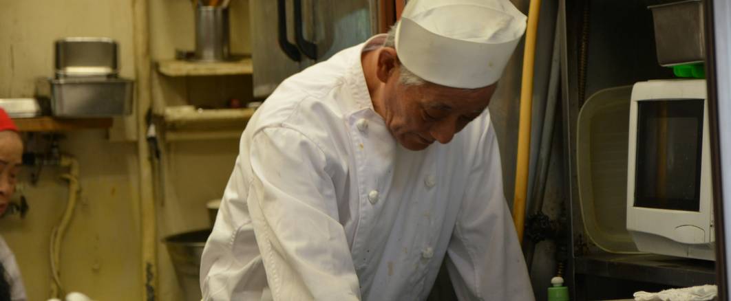 Chef checking a refrigerator thermometer in a commercial kitchen
