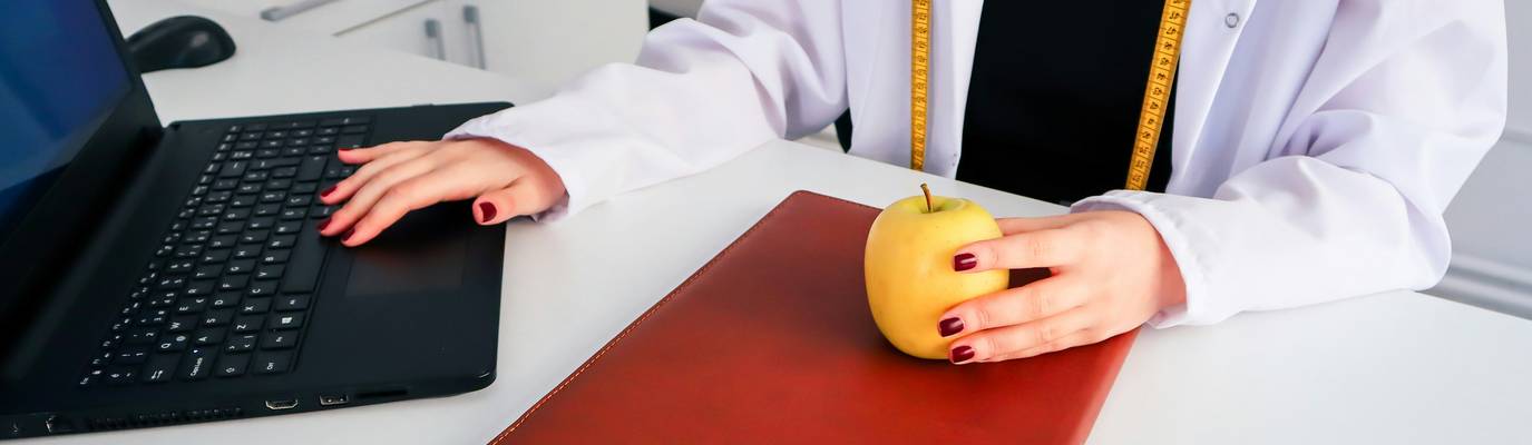 Trainee compares online laptop course with classroom workbook to decide on food handler training