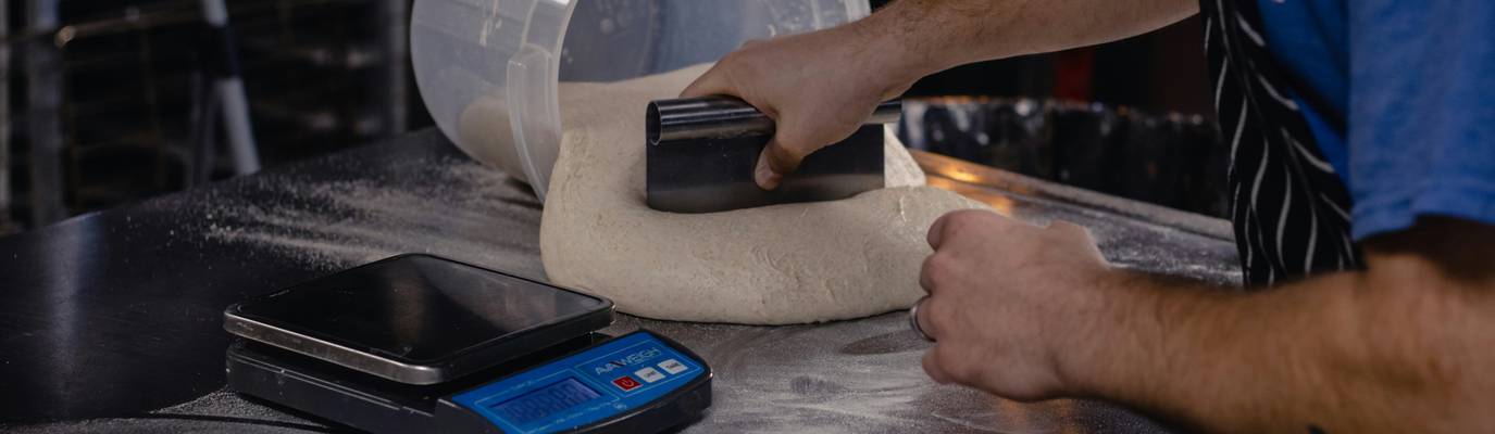 Commercial kitchen staff using a digital tablet to check food-safety calculators